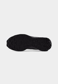 Black rugged shoe sole with deep treads designed for traction, shown against a plain light background.