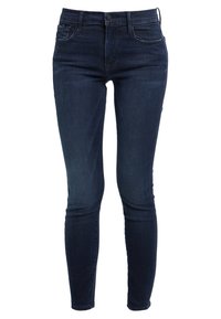 Jeans ajustados de color azul oscuro, hechos de denim, que cuentan con un clásico diseño de cinco bolsillos, trabillas para cinturón y un cierre frontal con botón.