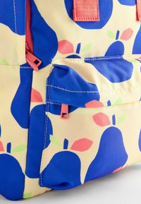 Zaino giallo con motivo di pere blu, arricchito da dettagli rosa e verdi. La texture è liscia, con zip e spallacci a contrasto.