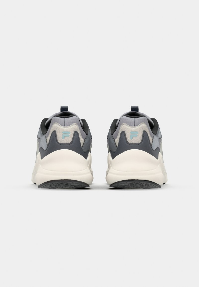 Baskets grises et blanches avec un dessus en maille texturée, des semelles en caoutchouc et une languette au talon ; arborent un logo bleu clair à l'arrière.