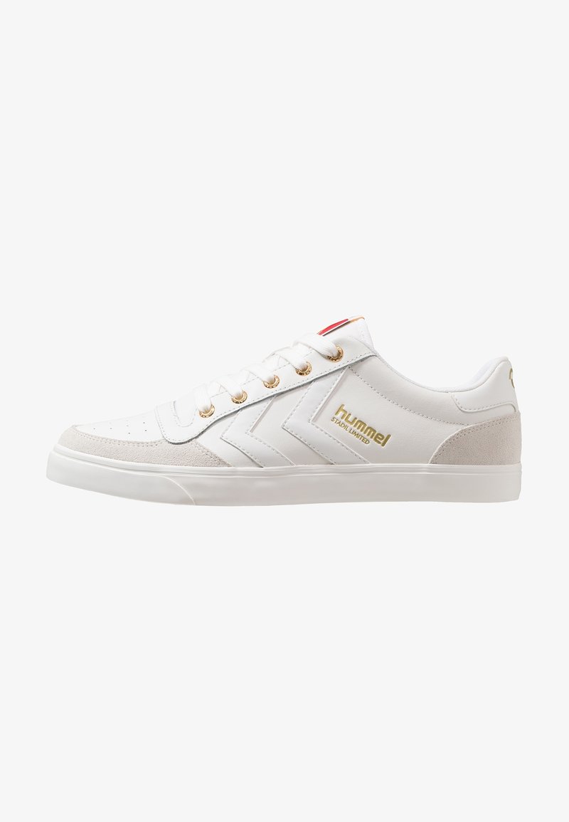 Baskets basses blanches avec œillets dorés, logo ""hummel STADIL LIMITED"" doré, motif chevron sur le côté et empiècements en suède beige à l’avant et au talon.