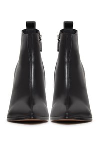 Botas de tobillo de cuero negro con un diseño elegante, puntera afilada y lados con cremallera. Presentan una textura suave y una estética minimalista.