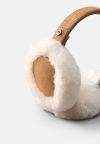 Auscultadores de pele falsa em tom creme com uma faixa na cabeça de camurça castanha texturizada, apresentando um design de almofada auricular circular e um detalhe de logo subtil.