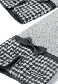 Guanti a maglia grigi con motivo houndstooth nero, dettagli in pelle nera e un piccolo fiocco. Presentano aperture per le dita per maggiore comodità.