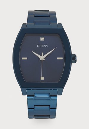 Montre en acier inoxydable bleu avec un cadran carré, un fond bleu foncé, des aiguilles argentées et des index horaires carrés. Elle est dotée d'un bracelet en maillons métalliques sécurisé.