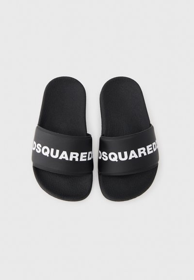 Șlapi negri cu talpă texturată și o bretea lată cu text alb îndrăzneț. Confecționați dintr-un material durabil și flexibil.