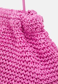 Rosa vävd väska gjord av texturerat garn. Har en samlad topp och ett robust handtag, vilket skapar en mjuk, rund form med synlig sömnad.