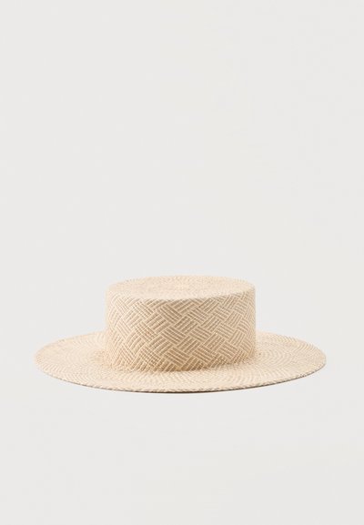 Πλατύγυρο μπεζ ψάθινο καπέλο με επίπεδη κορυφή και γεωμετρικό μοτίβο ορατό στην ύφανση.