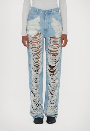 Jeans azzurri chiari con strappi grandi, bordi sfrangiati e vestibilità a gamba dritta. Presentano tasche frontali e un design a vita alta.