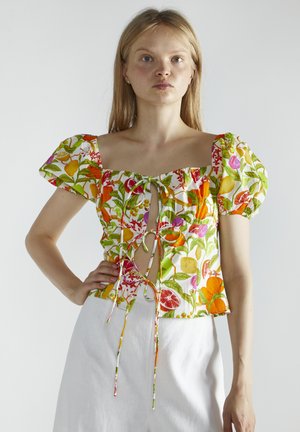 Blomstret top med pufærmer og firkantet udskæring. Har en frontknude og vibrerende farver, herunder grøn, pink og orange.