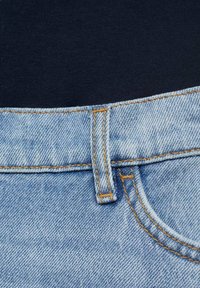Jeans de mezclilla de color azul claro con una cinturilla oscura. Presentan costuras naranjas y un pasador estándar en la parte superior. Textura de tejido suave.