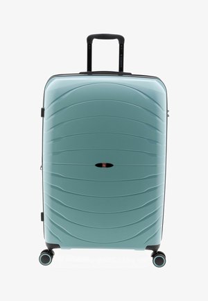 Valigia rigida di colore azzurro chiaro con manico telescopico nero e quattro ruote doppie girevoli, in posizione verticale su sfondo bianco.