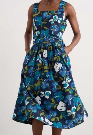 Mouwloze marineblauwe jurk met een vierkante halslijn en een bloemenprint in blauw, wit en groen, met een getailleerde taille en zakken.