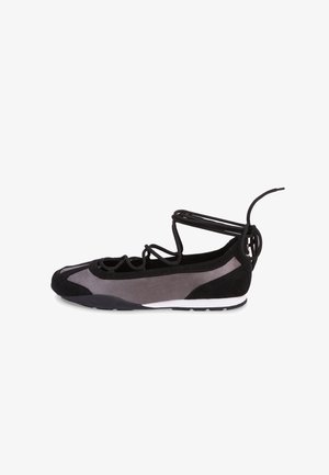 Zapatilla de ballet plana negra y gris con diseño de cordones cruzados y lazos para envolver el tobillo, con suela de goma blanca y negra.