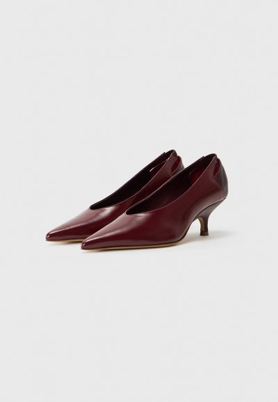 Burgundy nahkahousut, joissa on terävä nenä, matala kaareva korko ja sivuilla leikkauksia, sileä pinta ja minimalistinen muotoilu.