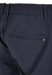 Shorts bleu marine avec une taille élastique, dotés d'une poche arrière avec un logo discret et d'un accent tricolore sur la bordure de la poche.