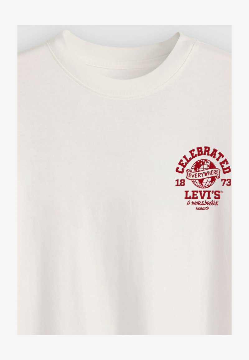 Hvid T-shirt med rød tekst og grafik på venstre bryst med teksten "Celebrated Everywhere 1873 Levi's A Worldwide Legend" og et globusikon.