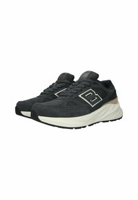 Scarpe da atletica nere con superiore testurizzato, caratterizzate da dettagli bianchi e una suola spessa color crema con un motivo rigato. Design con lacci.