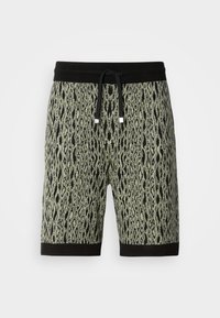 Shorts en tricot avec imprimé léopard noir et vert olive, taille élastique noire, cordon de serrage et détails d'ourlet noirs.
