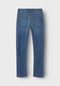 Jean en denim bleu foncé présentant une coupe ajustée, des jambes droites et deux poches arrières avec des coutures renforcées.