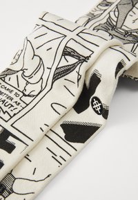 Cotton fabric scarf featuring a comic-style black and white print. Folded design reveals contrasting textures and graphic elements.