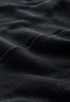 Zwarte stof met een zachte textuur, voorzien van fijne ribbels en subtiele kreukels, gericht op de rijke diepte en het gladde uiterlijk van het materiaal.