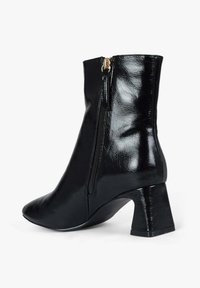 Stivaletto nero alla caviglia in materiale sintetico lucido, con zip laterale, punta appuntita e tacco a blocco. Texture liscia e design elegante.