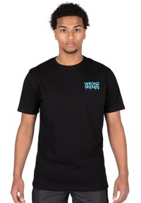 Camiseta de algodón negra con un logo turquesa "WRONG FRIENDS" en la parte izquierda del pecho. Diseño de mangas cortas y cuello redondo.