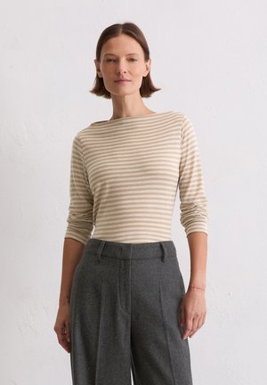 Lichtbeige langkleurig top met dunne verticale strepen, met een bootnek. Gecombineerd met hooggewaisted, op maat gemaakte grijze broeken.