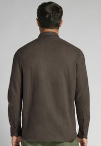 Langsleeve shirt in donkerbruin, gemaakt van een lichte stof. Heeft een klassieke kraag en knoopmanchetten. Eenvoudig ontwerp zonder patronen.