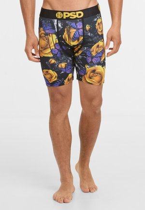 Schwarze Boxershorts mit goldenem Logo-Bund, ausgestattet mit einem floralen Design aus gelben Rosen und lila Schmetterlingen auf einem dunklen Hintergrund.