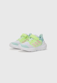 Chaussures de sport légères en vert, rose et blanc. Elles possèdent une tige en mesh respirant, une sangle Velcro et une semelle rembourrée.