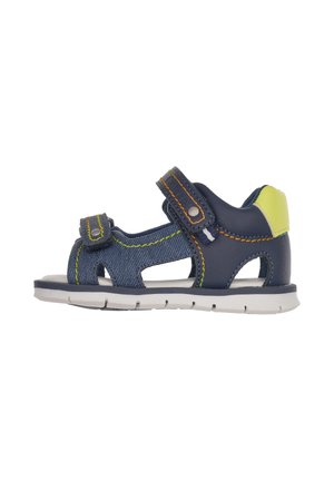 Mørkeblå sandal med denimtekstur, to justerbare stropper, gule detaljer og en hvid sål. Åben design for åndbarhed.