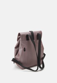 Zaino mauve con patta superiore, tasca frontale con zip e spallacci neri regolabili su sfondo bianco.