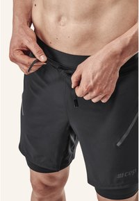 Zwarte sportshorts met een gladde textuur, voorzien van een trekkoordsluiting en subtiele grijze accenten aan de zijkanten en in de tailleband.