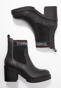 Mustat nilkkurit, jotka on valmistettu tekstuuripintaisesta nahasta ja kankaasta. Varustettu lohkarepohjalla, joustavilla sivupaneeleilla ja logonauhalla ylhäällä.