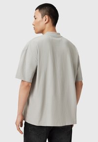 Oversized kortærmet t-shirt i lysegrå bomuldsstof med rund halsudskæring og en afslappet pasform, med minimale syninger.