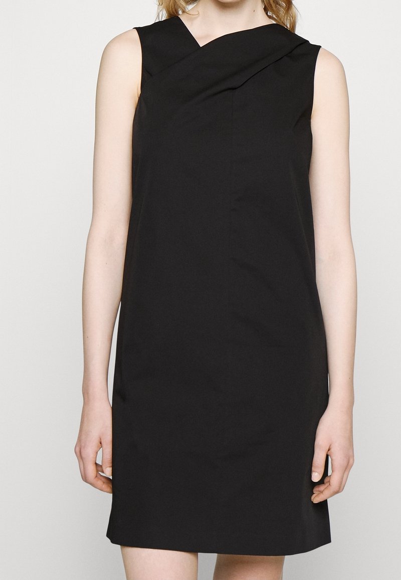 Černé šaty bez rukávů s designem zakřiveného ramene, vyrobené z hladkého materiálu, s přiléhavým siluetou a délkou ke kolenům.