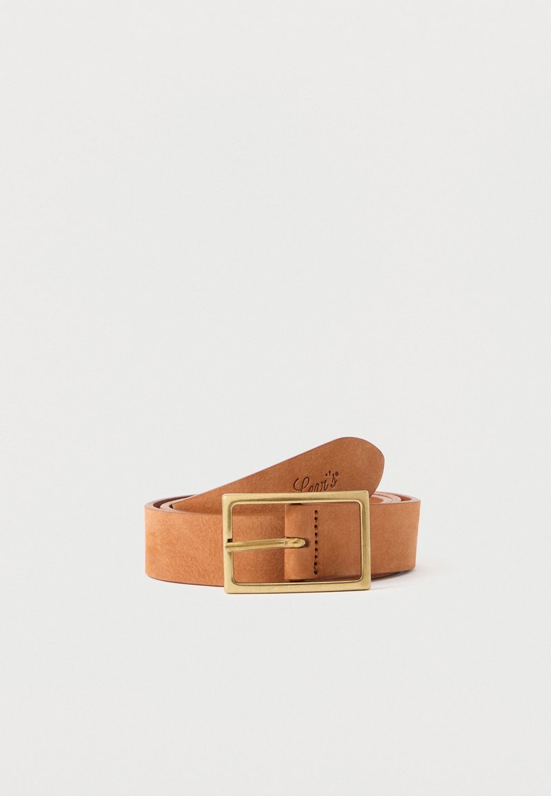 Ceinture en cuir fauve enroulée avec une boucle rectangulaire en laiton reposant à plat sur une surface grise claire.