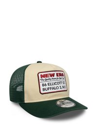 Zaļa un bežīga snapback cepure ar taisnstūrveida izšūtu uzšuvi, kurā ir "NEW ERA" un teksts. Acs aizmugure, izliekta viziera un strukturēta forma.