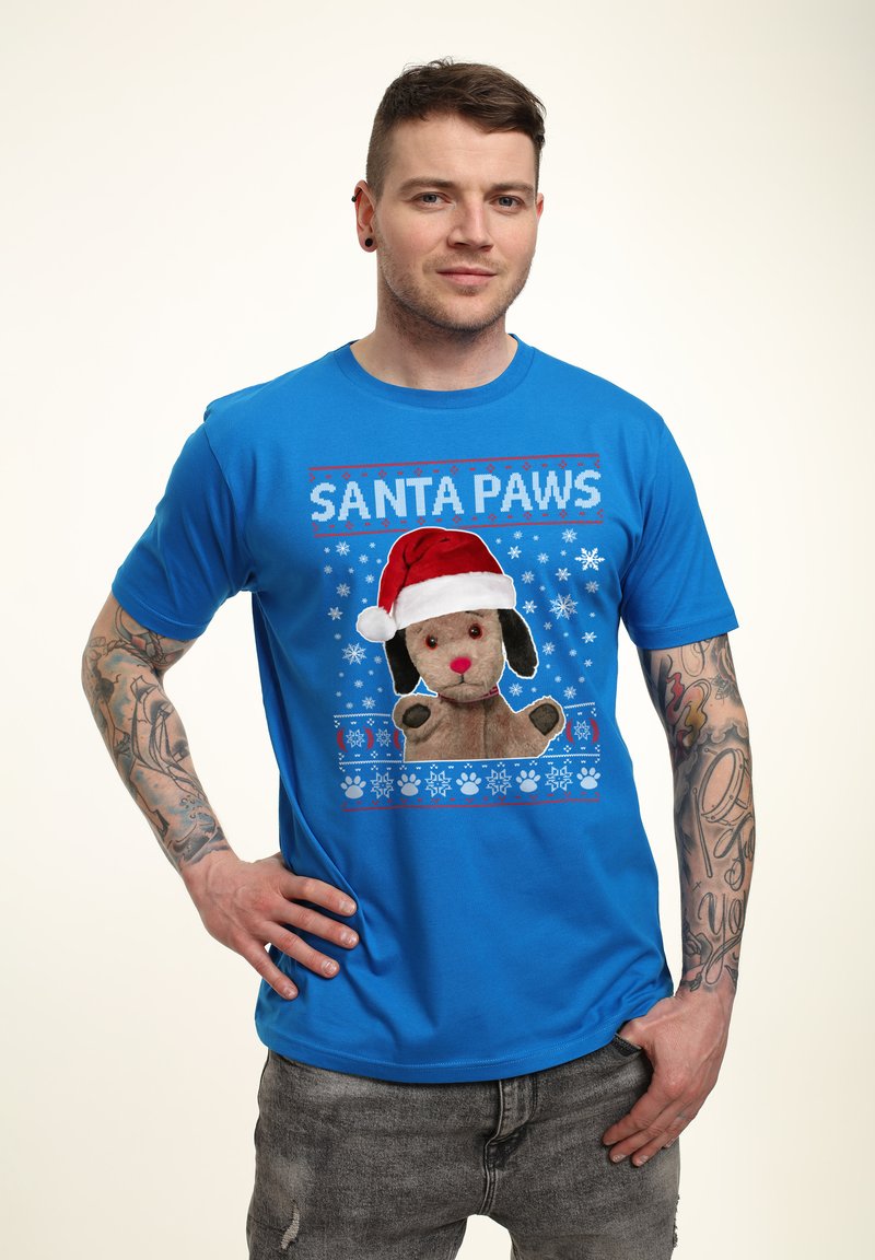 Maglietta blu a maniche corte con un cane di peluche che indossa un cappello di Babbo Natale, con il testo "SANTA PAWS" e decorazioni a forma di fiocchi di neve.