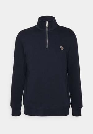 Sudadera con cremallera de color azul marino que presenta un alto cuello, mangas largas y un pequeño logo bordado en el pecho. Fabricada en un material suave.