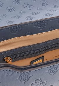 Sinine reljeefne kunstnahast käekott, mille sisemus on kaetud beežiga kangaga, sisaldab lukustatavat sektsiooni ja kuldset aksessuaaride viimistlust.