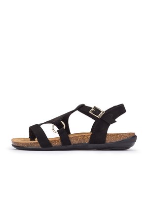 Schwarze Sandale mit offenem Zehenbereich, überkreuzten Riemen, goldener Schnalle und Kork-Fußbett auf einer flachen schwarzen Sohle vor weißem Hintergrund.