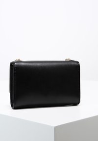 Svart läderplånbok med en slät yta, rektangulär form och minimalistisk design. Utrustad med detaljer i guldfärg och dragkedjestängning.