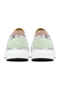 Zapatillas blancas con un detalle en el talón verde, acentos plateados y una pestaña de ante rosa. Materiales lisos y texturizados con una suela blanca gruesa.