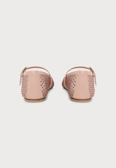 Paire de chaussures plates rose blush avec brides à la cheville et détails cloutés sur les côtés et à l'arrière, vues de derrière.