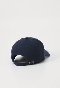 Navy baseball cap viewed from the back, featuring an adjustable strap and subtle decorative stitching. Simple, solid color design.