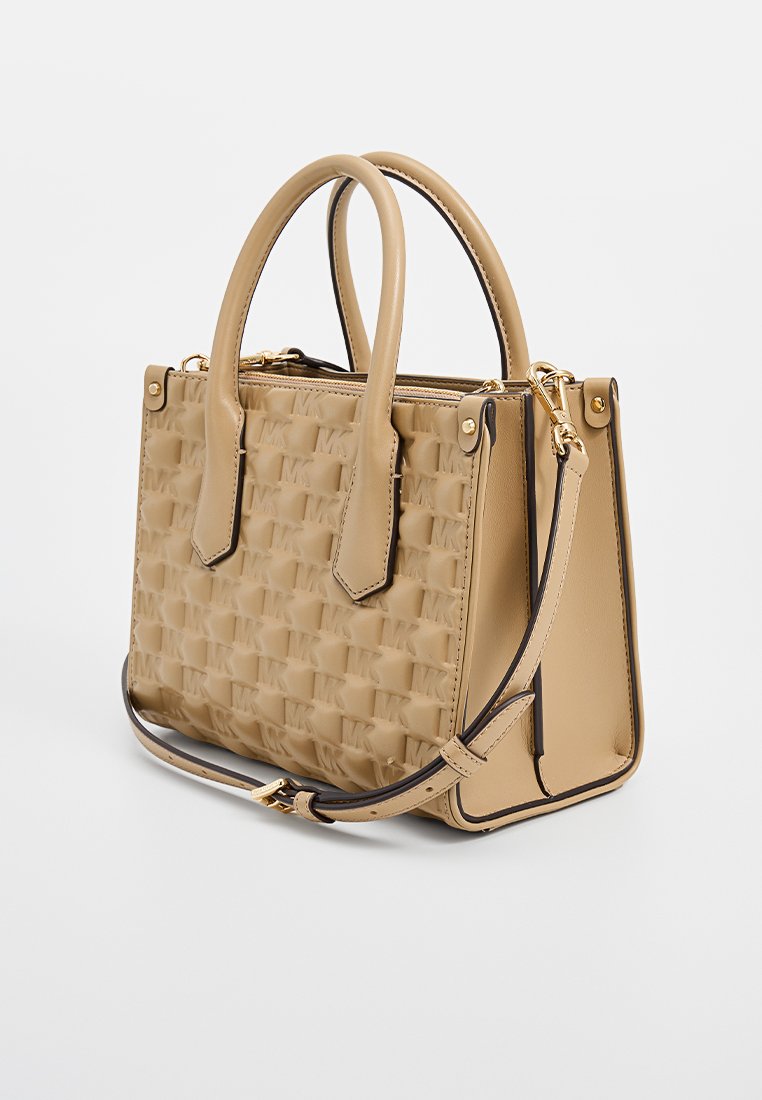 Sac à main beige en cuir texturé avec un motif tissé, poignées courtes et une bandoulière détachable. Équipé de quincaillerie dorée.