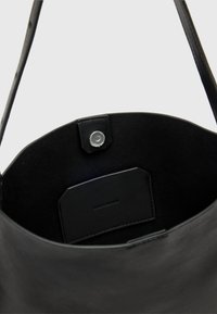 Fekete bőr bevásárlótáska sima textúrával és struktúrált dizájnnal. Kattintásos zárással és az "ALLSAINTS" felirattal domborított címkével rendelkezik.